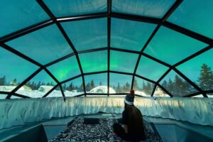 Aurora borealis shining in the night sky seen from Glass Igloos-cm