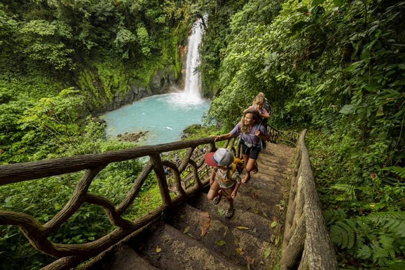 A family hiking at Rio Celeste waterfall in Costa Rica.-cm