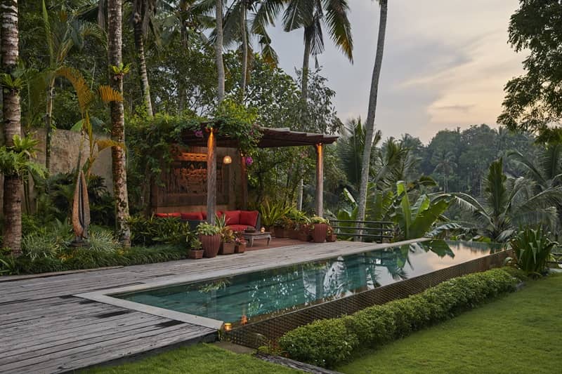 Sitting area next to pool at luxury villa situated amongst tropical plants and valley view-cm